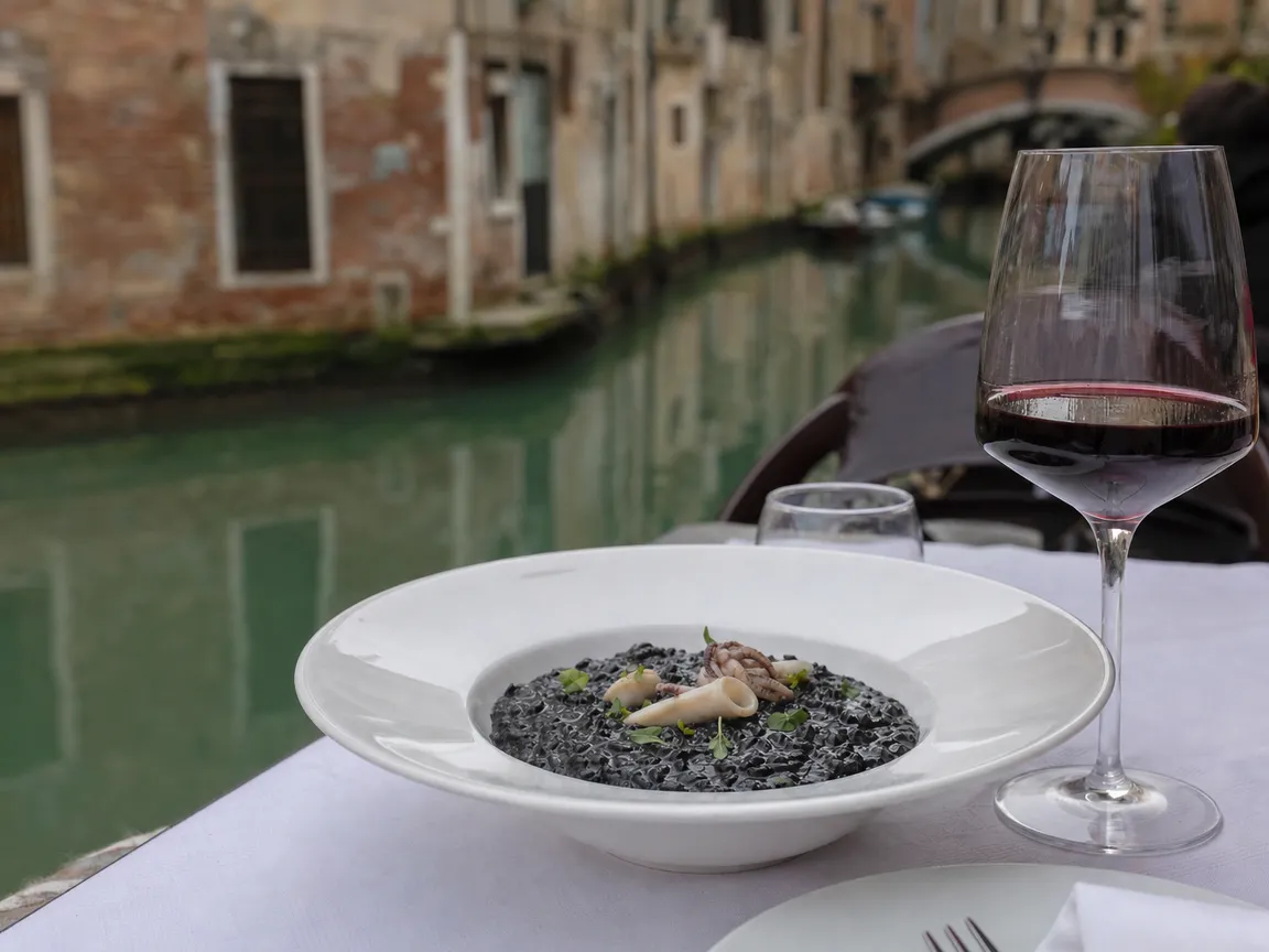 Risotto al nero di seppia su un tavolo vicino al canale